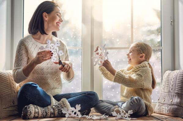 Window installation next to mother and daughter cutting out snowflakes.